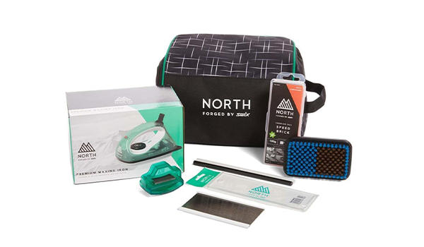 Ski and snowboard tune kit including a waxing iron, edge sharpener, plastic and metal wax scraper, universal temperature wax, wax brush, and carrying case.